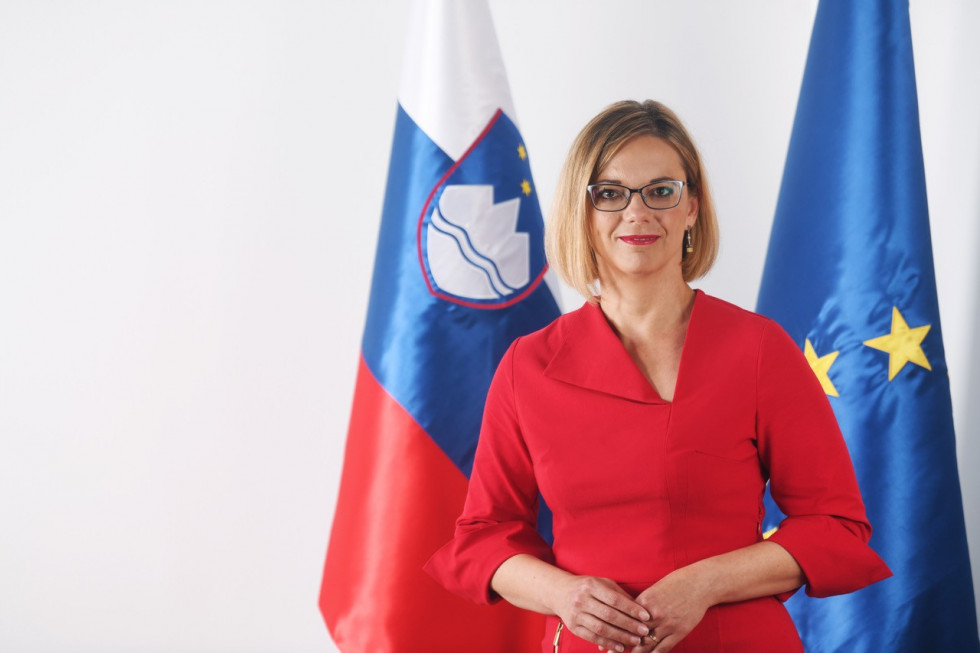 Ministrica, ki stoji ob slovenski zastavi