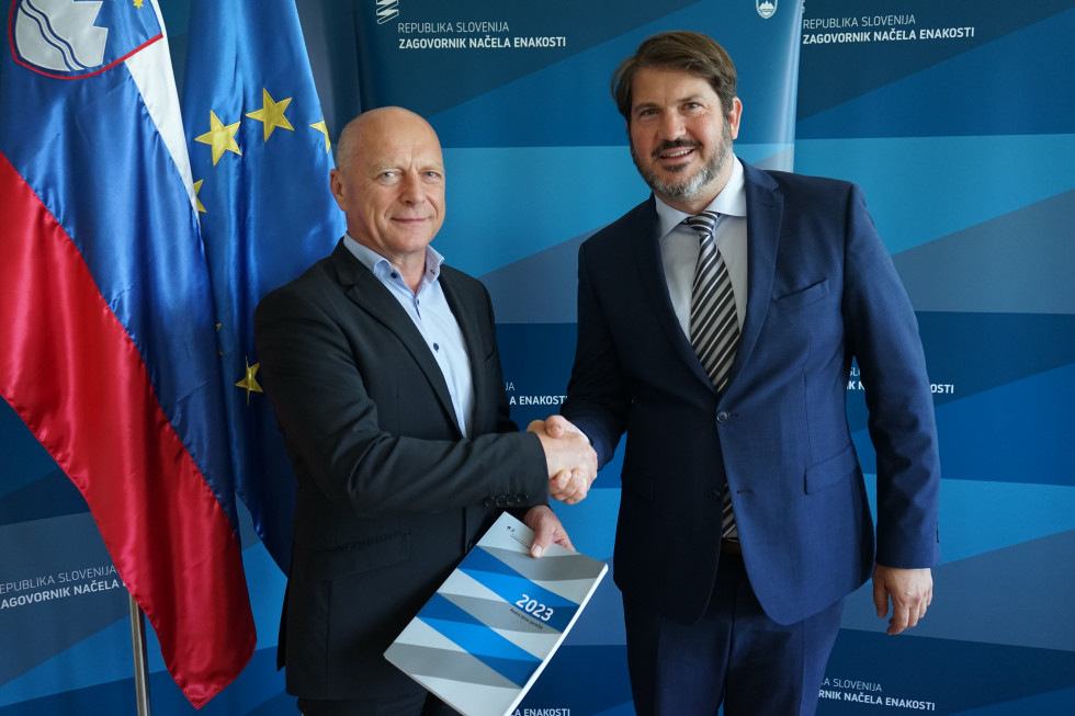 Franc Props v roki drži poročilo in se rokuje z Miho Lobnikom