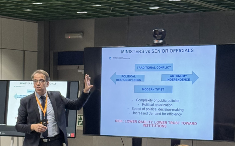 generalni direktor stoji pred prosojnico in razlaga