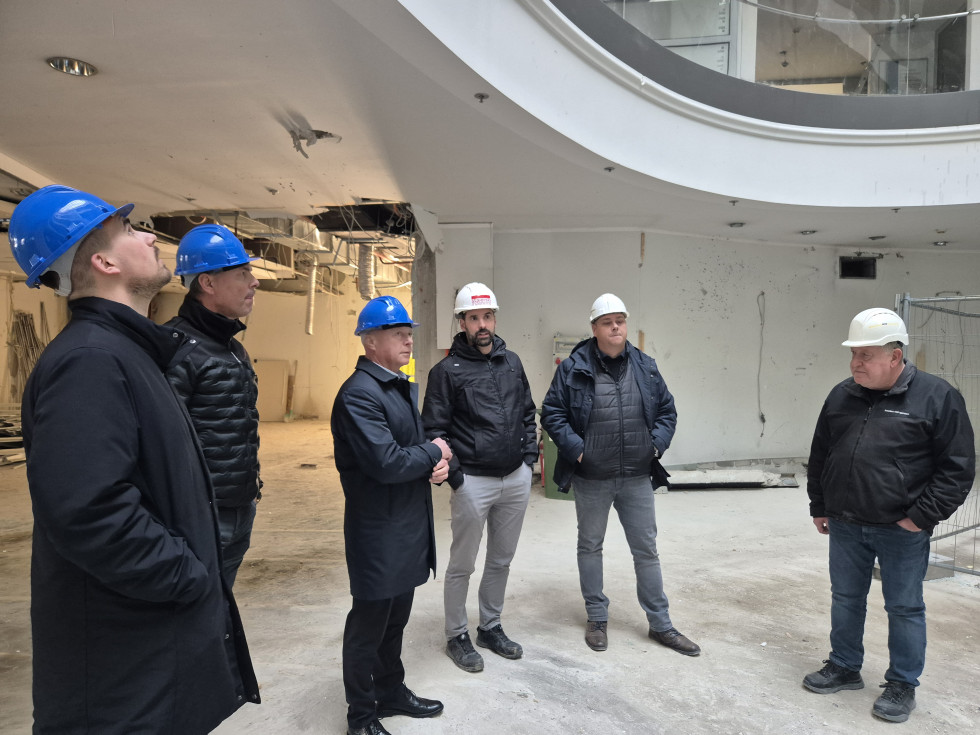 Na gradbišču upravne enote Maribor  je minister obkrožen z izvajalci del.