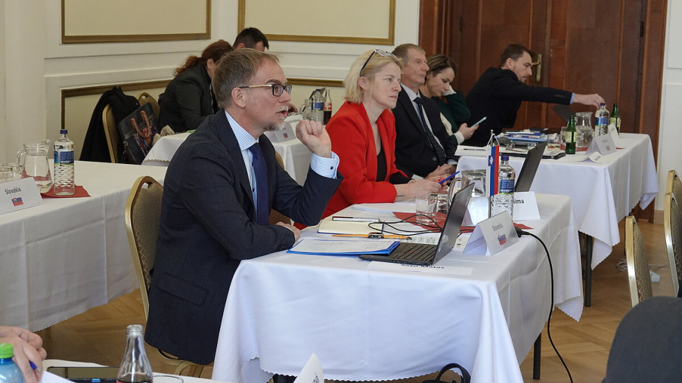 Omenjena sedita v dvorani za mizo in poslušata