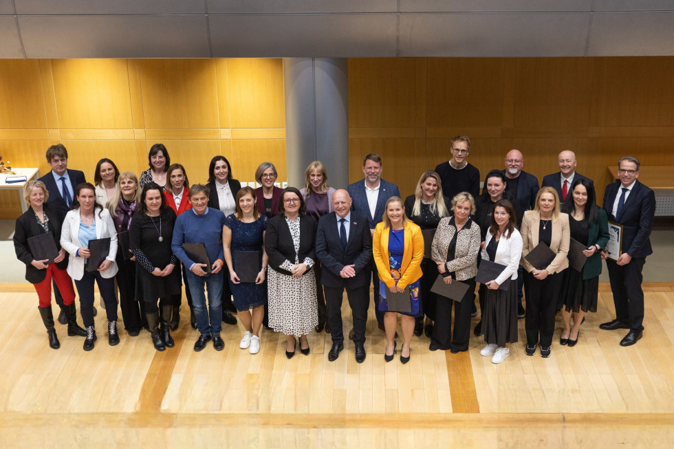 Skupinska fotografija prejemnikov priznanj ob ministru in državni sekretarki.