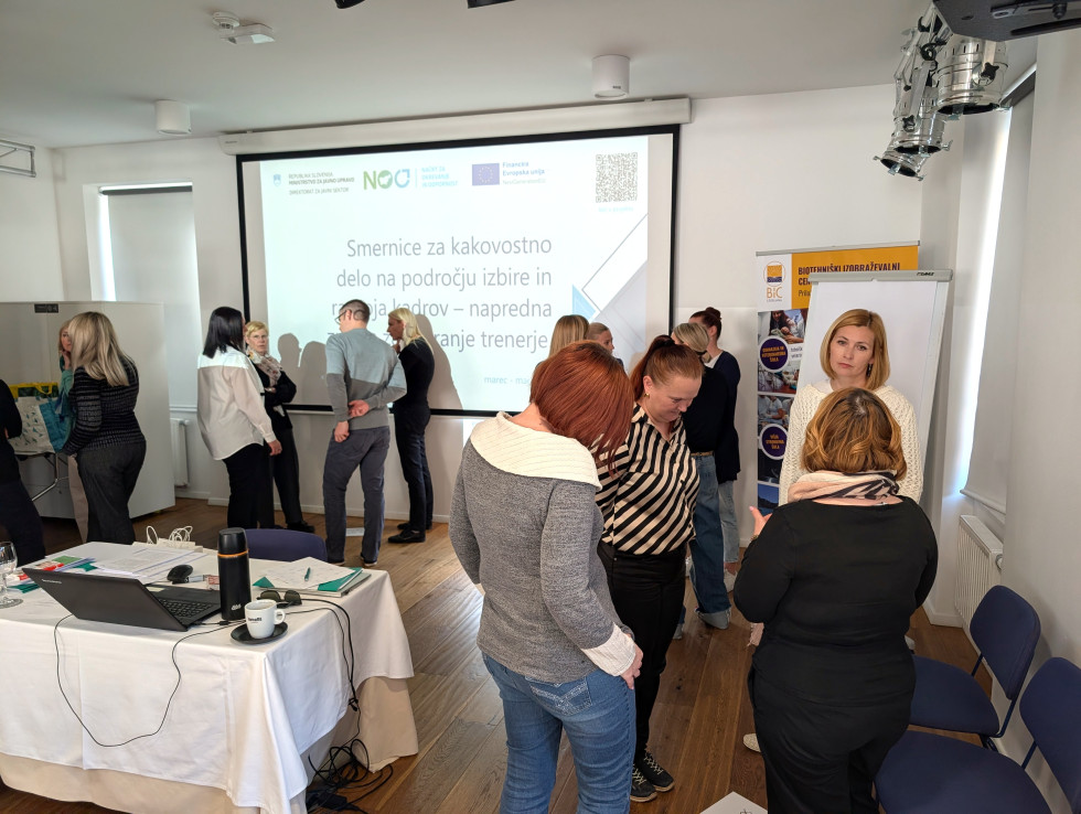 udeleženci usposabljanja stojijo v skupinah in debatirajo