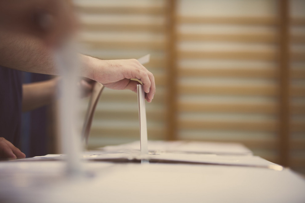 roka, ki oddaja glasovnico v volilno skrinjico