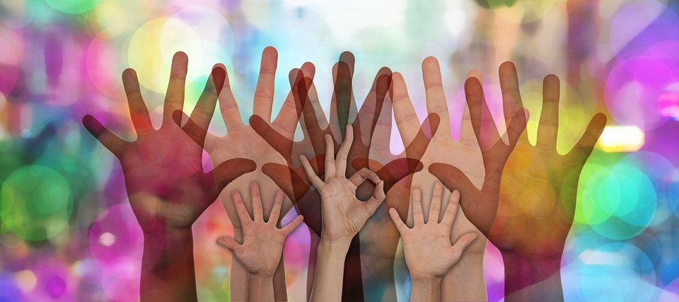 Na fotografiji so različno velike roke, dlani, kot simbol prostovoljstva in povezovanja ter solidarnosti