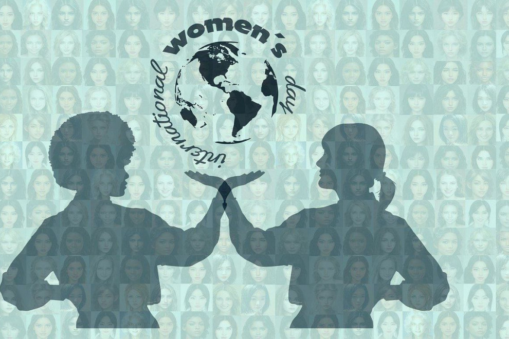 Simbolična fotografija: dve ženski imata dlan pod zemljo (globus), na fotografiji piše International woman's day