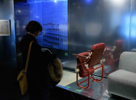 Obiskovalka si ogleduje razstavljen rdeč stol