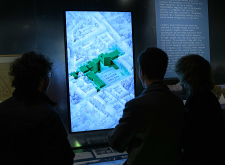 Obiskovalci si ogledujejo razstavljen digitalni pano