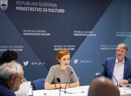 Ministrica dr. Asta Vrečko sedi pred mikrofonom