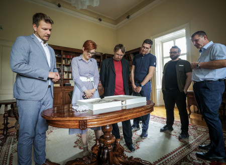 Ministrica se v spremstvu direktorja sklanja nad knjigo v Koroški osrednji knjižnici dr. Franca Sušnika