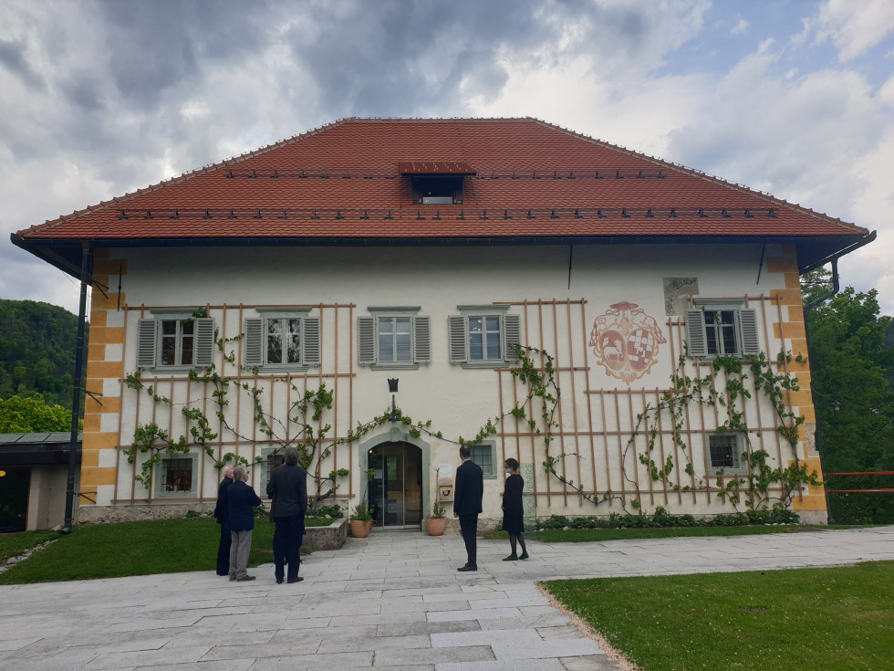 Pogled od spredaj na pročelje zgradbe proštije in na hrbte tistih, ki so si prišli ogledat prenovljeno zgradbo proštije