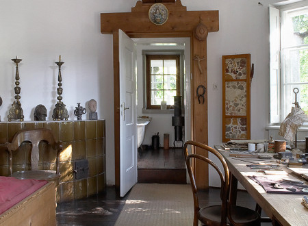 Pogled v kopalnico iz Plečnikove svetle spalnice s posteljo na desni in delovno mizo na levi strani.