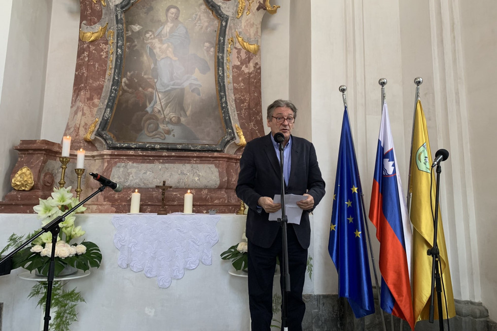 Minister za kulturo pred mikrofonom nagovarja zbrane na slovesnosti ob zaključku obnovitvenih del v kapeli dvorca Dornava