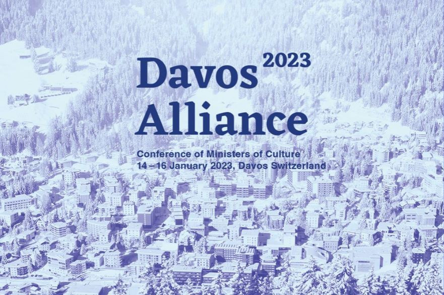Pasica s panoramo na zasneženo mesto Davos in z napisom, ki napoveduje konferenco ministrov za kulturo, ki bo leta 2023 v Davosu