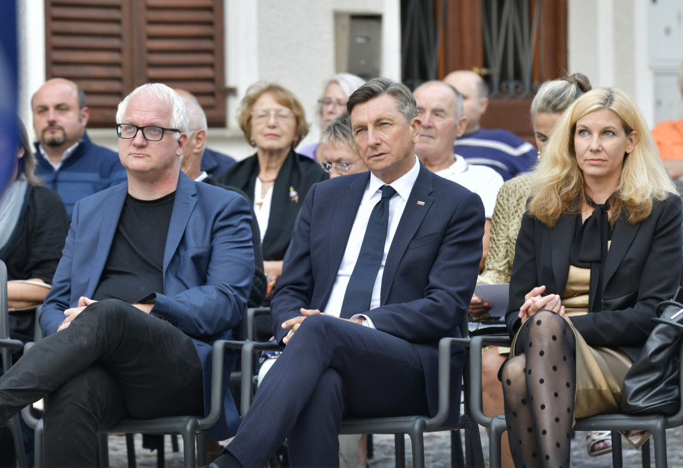 Pogled od spredaj na sedeče občinstvo, v prvi vrsti dva moška in ženska