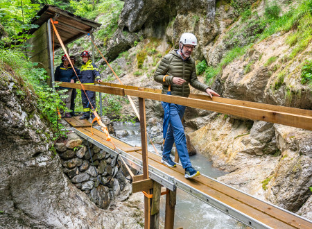 Direktor Urada znaka evropske dediščine hodi po leseni brvi na območju poškodovane bolnice Franja