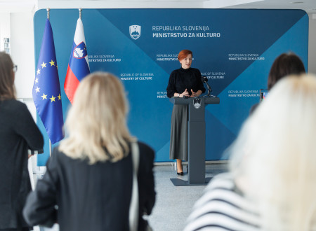 Ministrica za kulturo stoji za govoriškim odrom in nagovarja zbrane