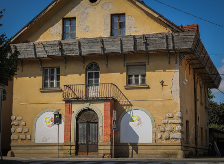 Razpadajoča rumena vhodna stran fasade Hiše Goliev trg 7