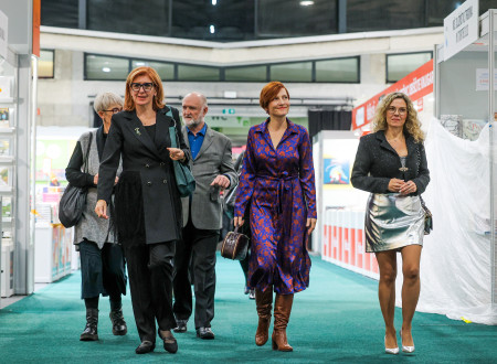 Ministrica za kulturo se v družbi s predstavniki organizatorjev knjižnega sejma sprehaja po prostoru, v katerem je sejem