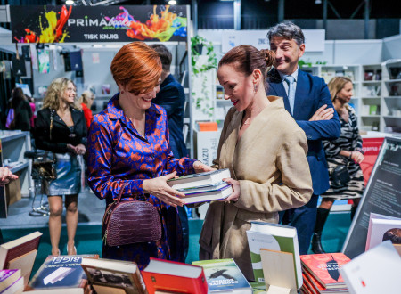 Predstavnica založbe ministrici za kulturo predaja v roke kup knjig