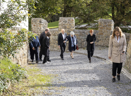 Ministrica za kulturo in županja v spremstvu predstavnikov občine in ministrstva hodita po tlakovani poti ob gradu navzgor
