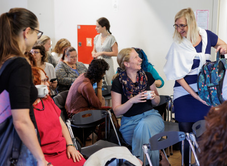 Udeleženci konference, nekateri sredi klepeta, nekateri gledajo v svoje telefone