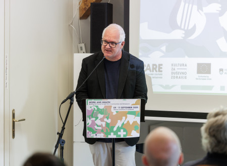 Državni sekretar stoji za govorniškim odrom in nagovarja zbrane