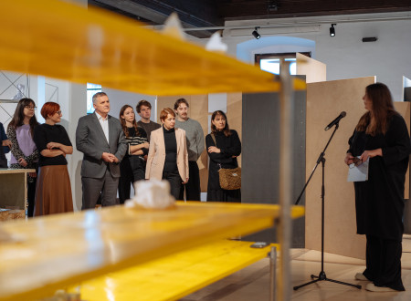 Pogled med policama na udeležence predstavitve projekta, med njimi ministrica in minister