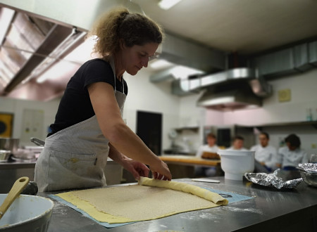 Ženska zvija testo, ki je namazan z orehovim nadevom 