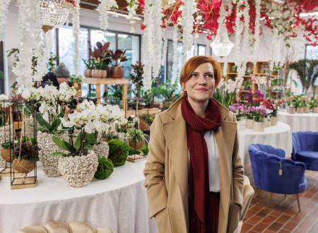 Ministrica za kulturo v sobi, napolnjenimi z belo-rdečimi rožami