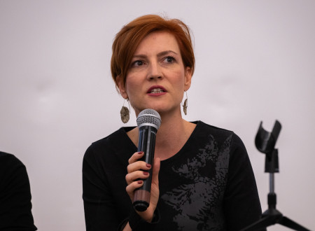 Ministrica za kulturo z mikrofonom v levi roki