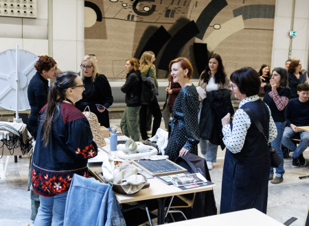 Ministrica za kulturo in obiskovalci Kulturnega bazarja se sprehajajo med mizami, ob katerih se predstavljajo kulturno-umetnostni projekti