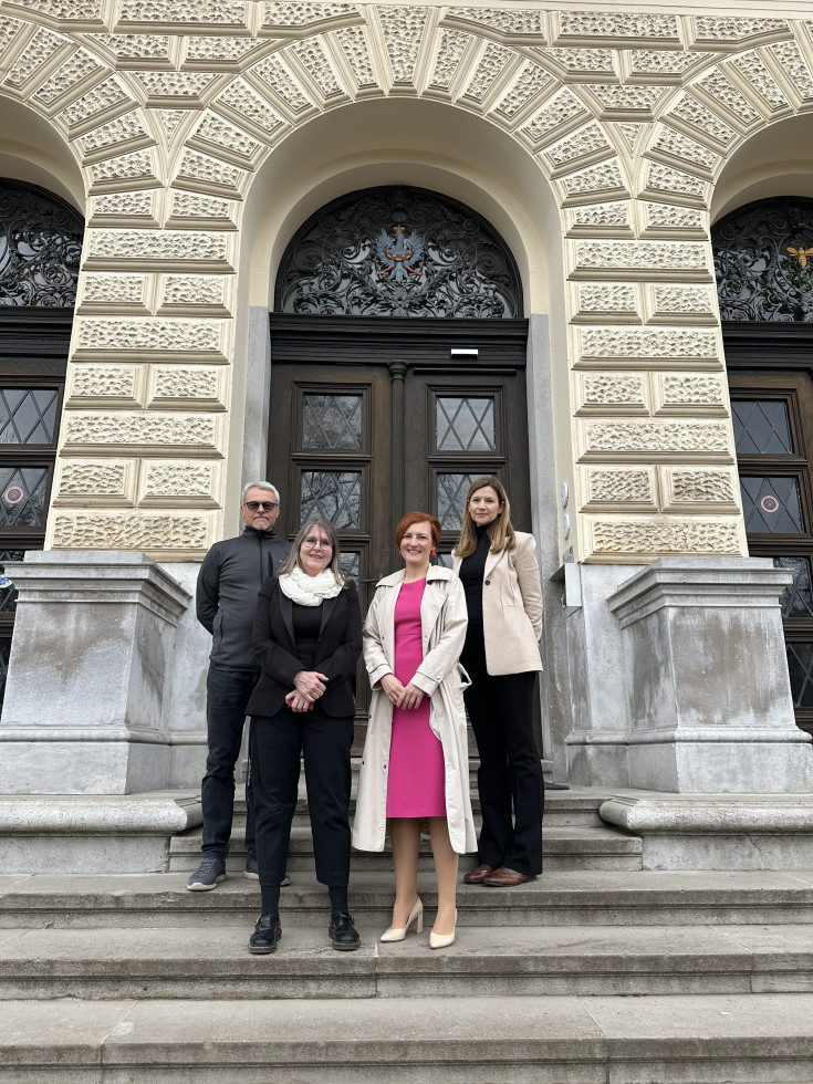 Direktorica, ministrica in vodji projekta stojijo na stopnicah pred vhodom v Narodni muzej Slovenije