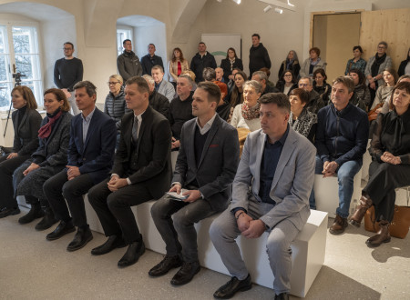 Sedeči in stoječi udeleženci dogodka v dvorcu ob odprtju prenoveljenega dvorca