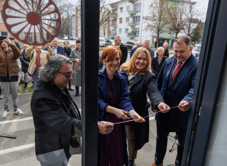 Predstavnici vlade, predstavnik romske skupnosti in župan režejo otvoritveni trak pred vhodom v muzej