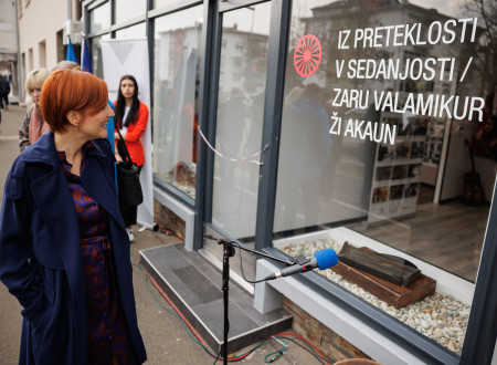 Ministrica pred vhodom v muzej, na steklu napis Iz preteklosti v sedanjost / Zali valamikur ži akaun