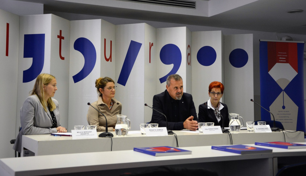 Minister Poznič med uvodnim nagovorom, ob njem sedijo predstavnike Javne agencije za knjigo