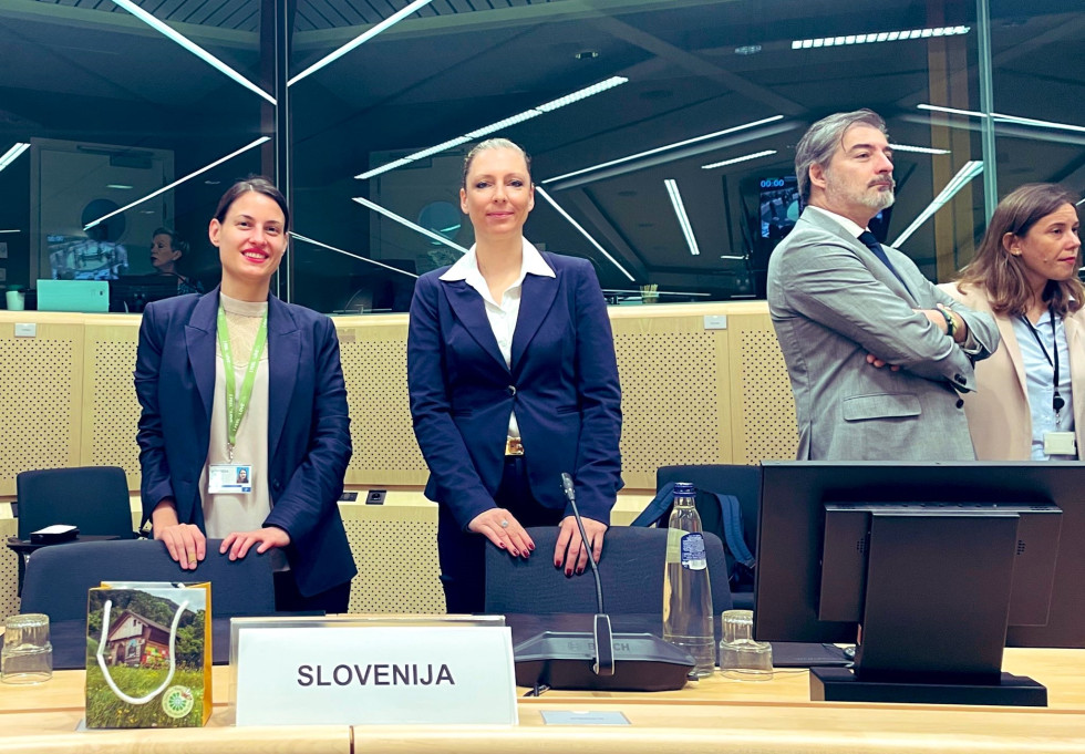 Štiri osebe v dvorani, v ospredju državna sekretarka Eva Knez.