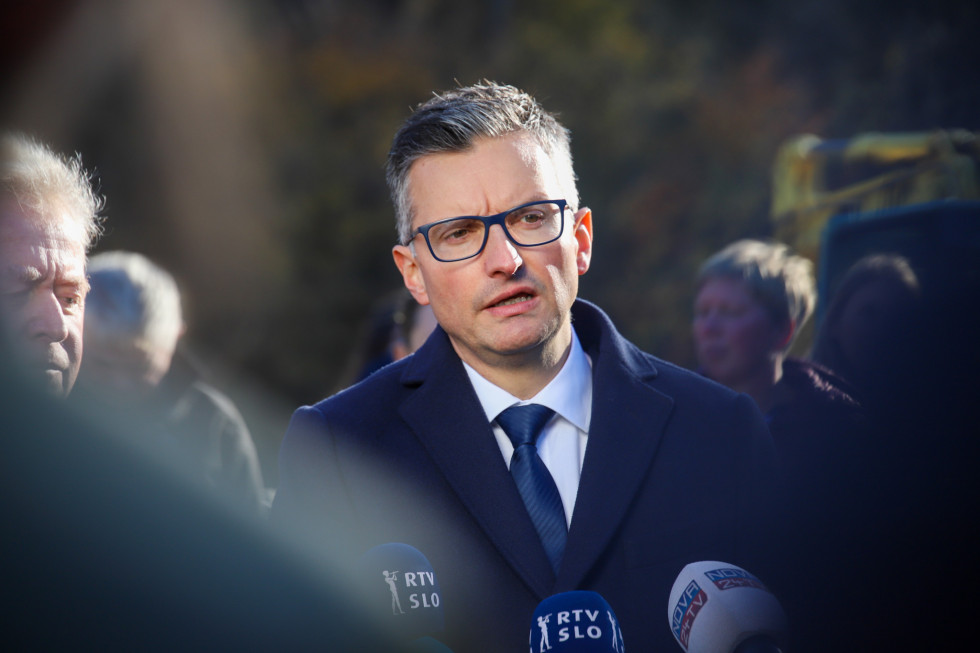 Minister pred mikrofoni novinarjev.