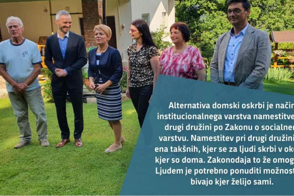 Ministrica v družbi štirih ljudi pred hišo