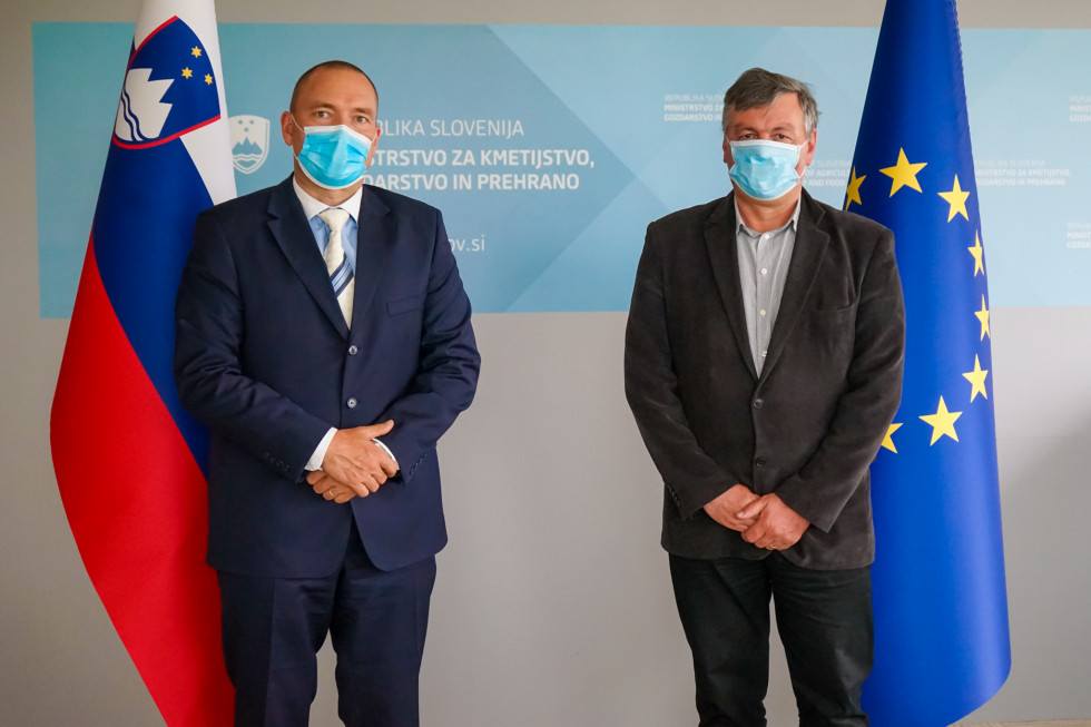 Minister dr. Podgoršek in Varuh odnosov v verigi preskrbe s hrano Hrovatič stojita pred logotipom MKGP