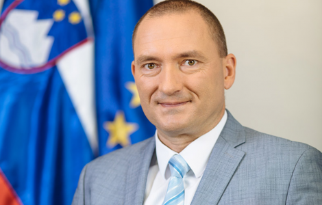 MINISTER (Minister in front of slovenian flag)