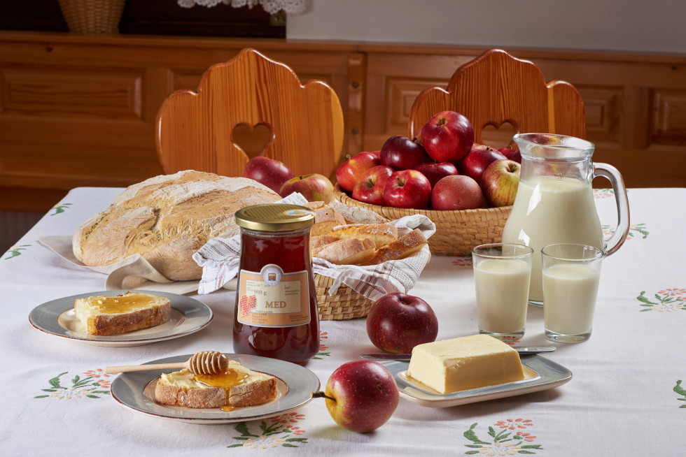 na mizi slovenski zajtrk: kruh z maslom in medom, mleko, jabolka