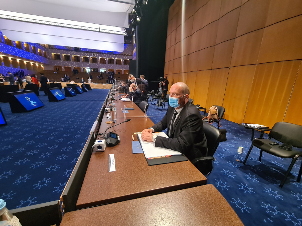 Minister dr. Jože Podgoršek v temni obleki sedi za miuo 