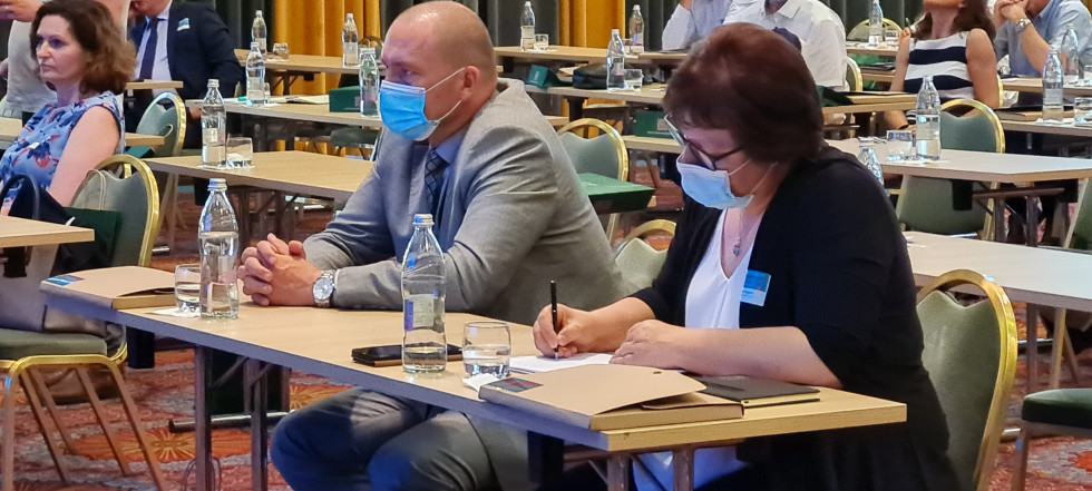 Minister v sivi obleki z direktorico Zbornice kmetijskih in živilskih podjetij Tatjano Zagorc sedi za mizo in spremlja okroglo mizo