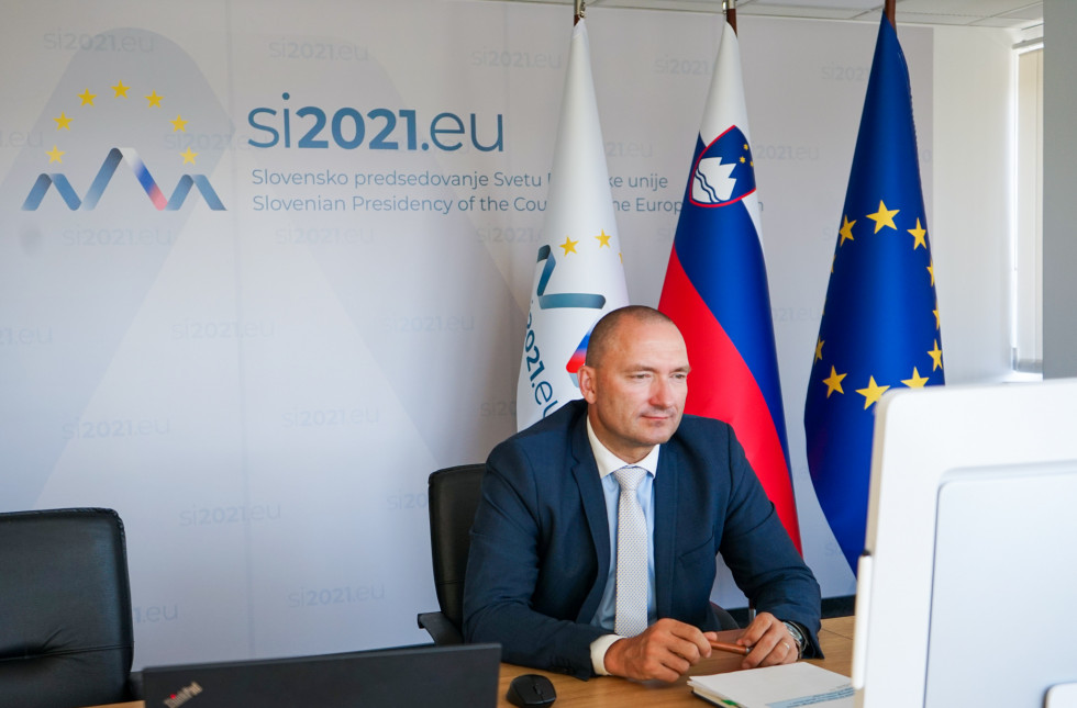 Minister in a grey dress sitting in front of a computer.