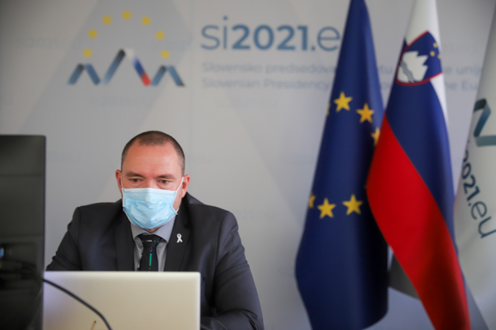 Minister med svojim nagovorom. Za njim zastave EU, Slovenije in predsedovanja