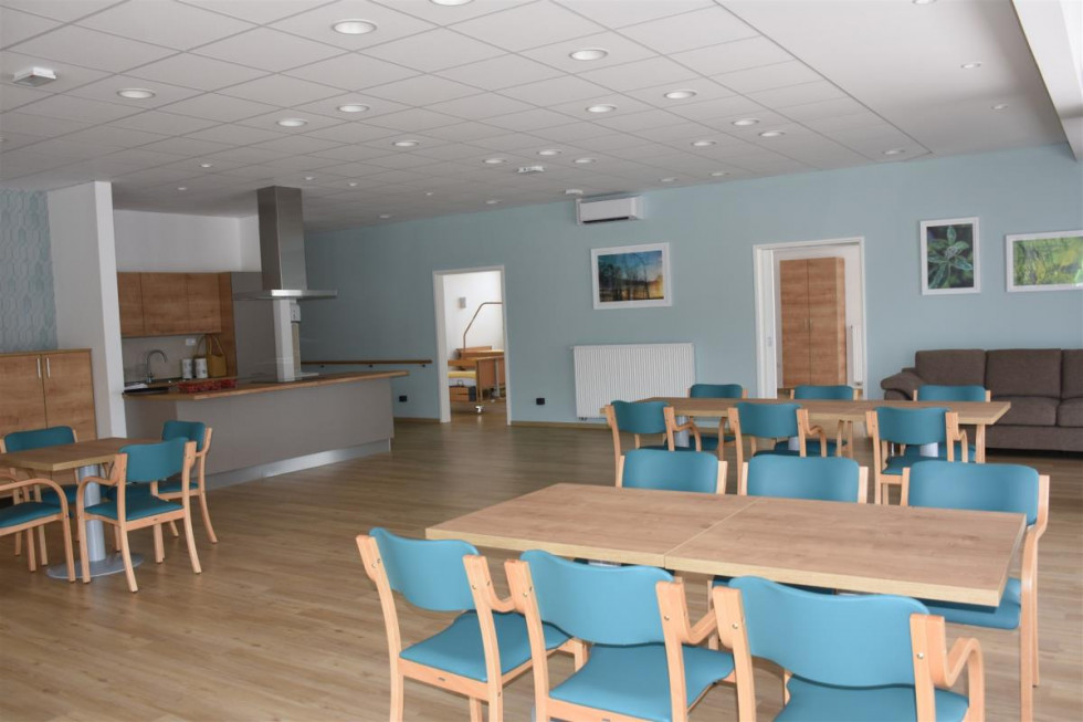 Day center for elderly people. A room full of chairs and tables. 