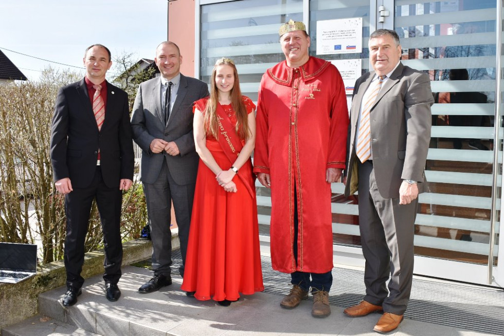 Minister stoji in se slika skupaj z kraljem in kraljico cvička. 