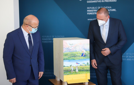 3 (Minister and ambassador standing and looking at the beehive.)